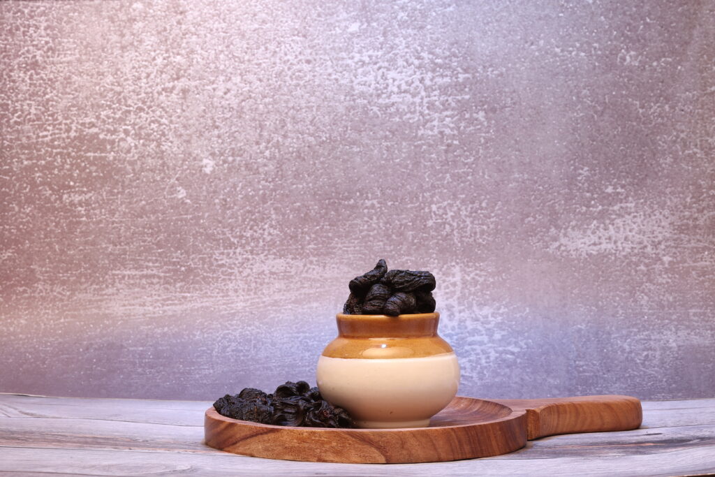 tamarind is in a jar placed on wooden plate