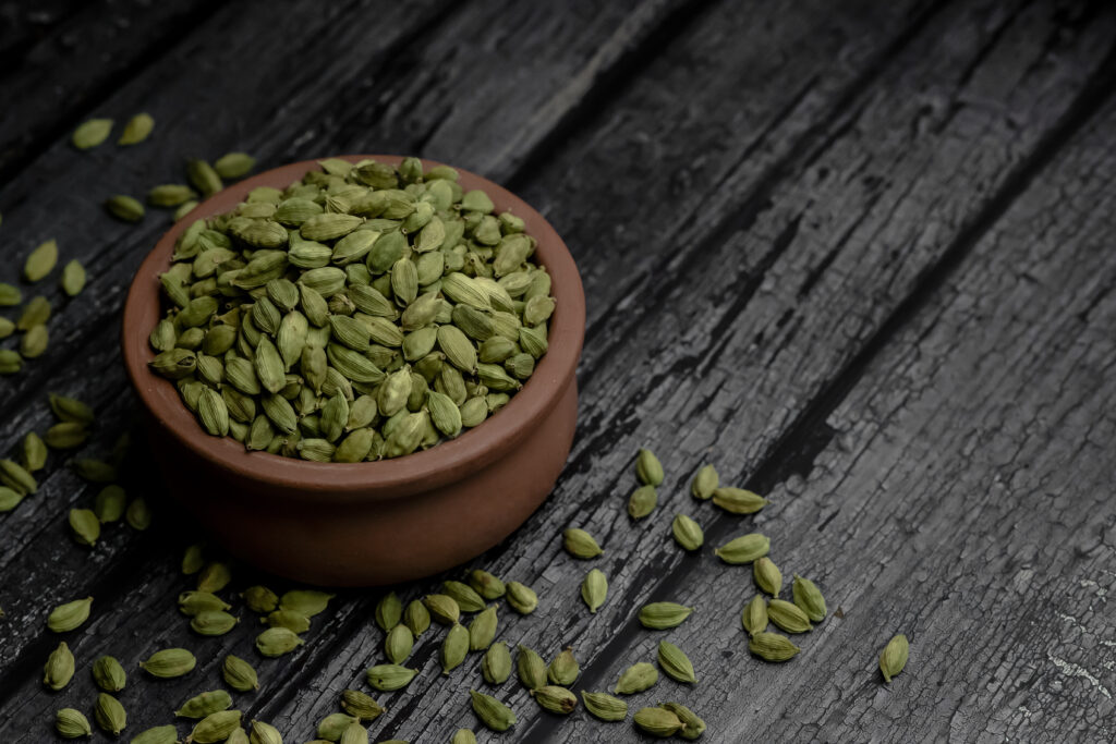 Fresh green cardamom placed on a wooden pot
