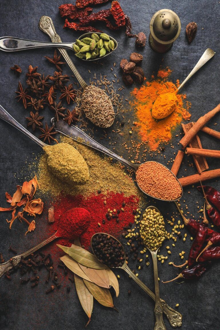 mix of spices and spice powders placed on a spoon in black background