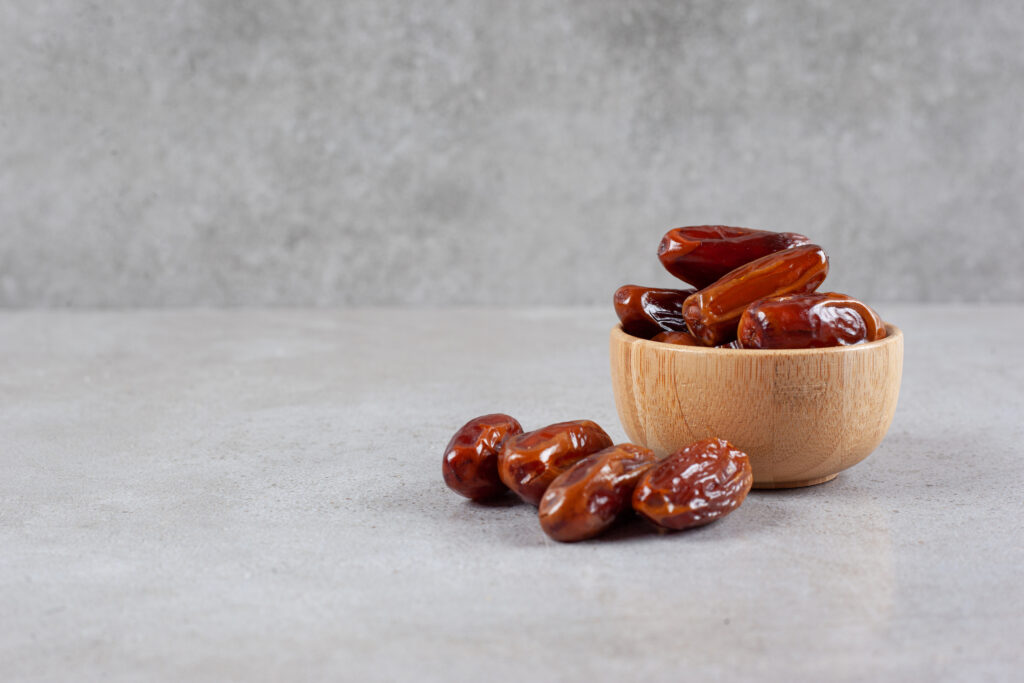 A small bowl of dates in marble background
